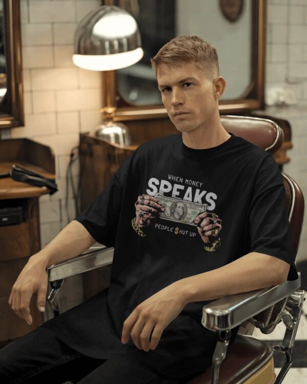 Male model wearing a black oversized t-shirt sitting in a retro-style barbershop chair