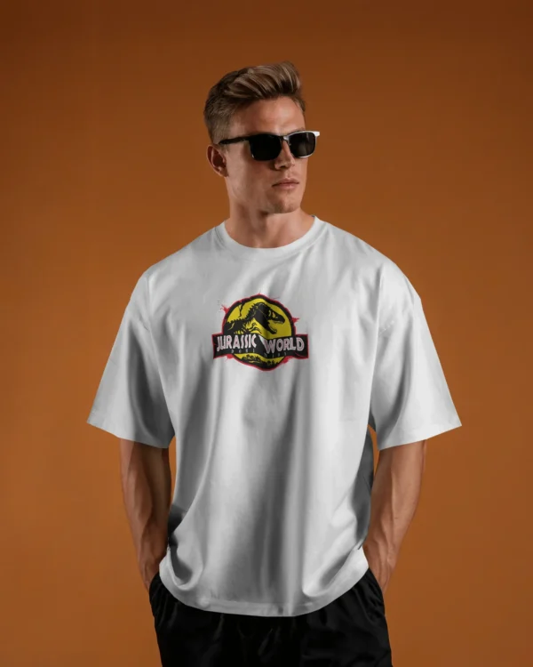Man wearing an oversized white round neck cotton t-shirt with Jurassic World print, standing outdoors among cacti in a desert setting