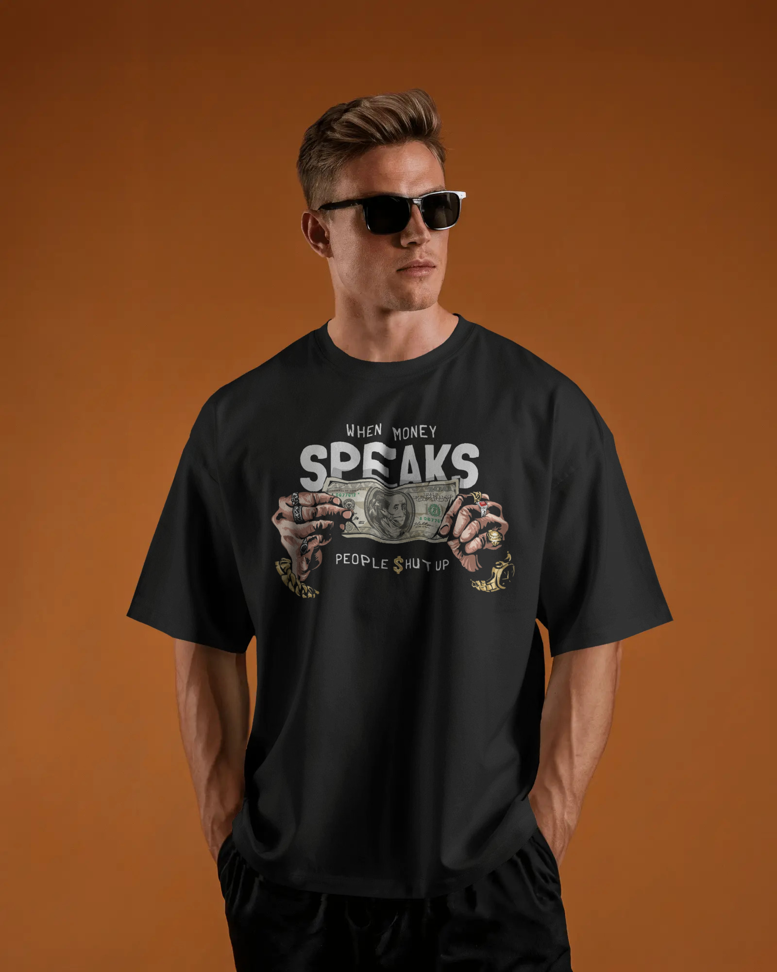 Stylish male model wearing a black oversized t-shirt and sunglasses against a bright orange background