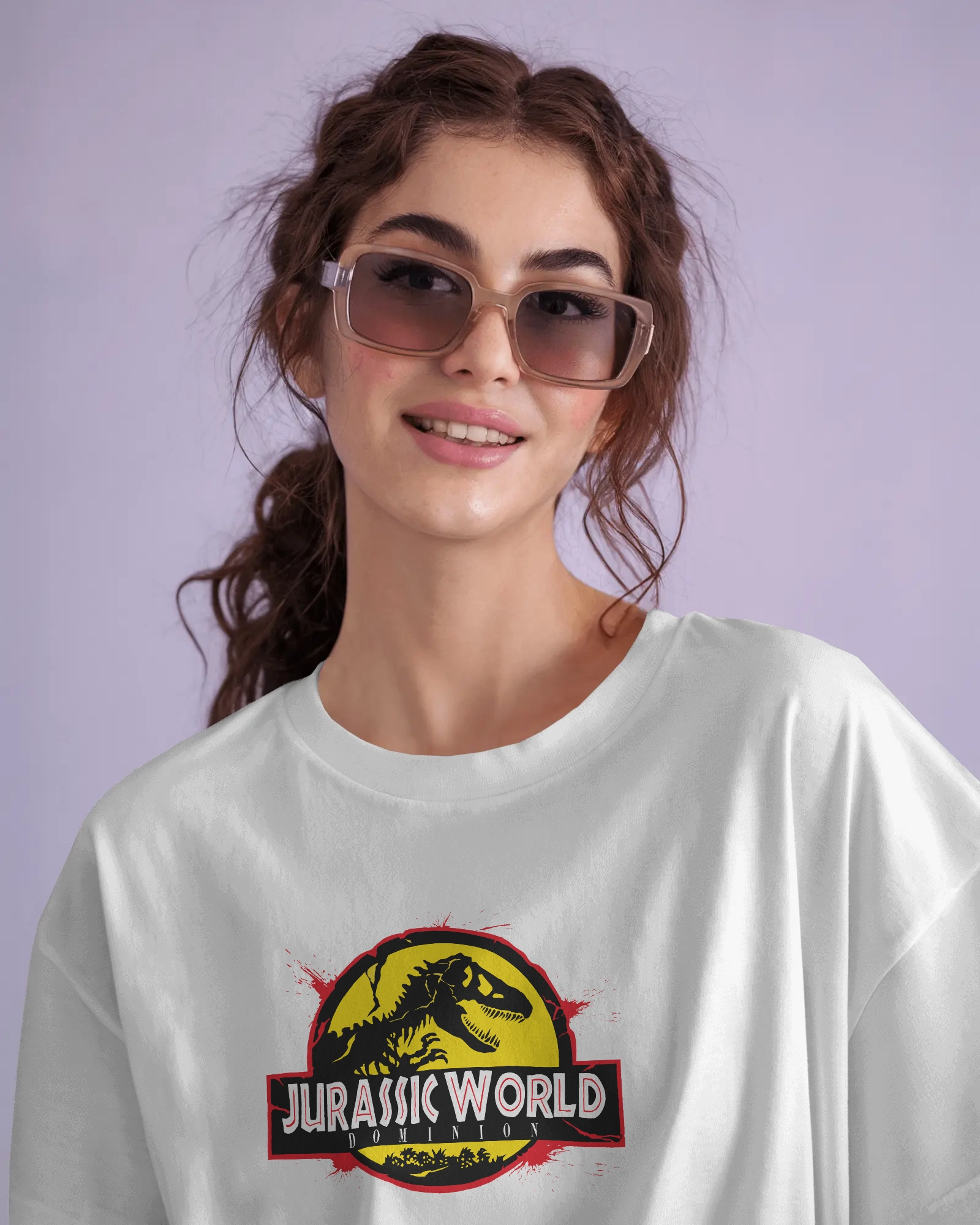 Man wearing an oversized white round neck cotton t-shirt with Jurassic World print, standing outdoors among cacti in a desert setting