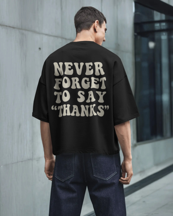 Black oversized unisex t-shirt with bold back print “Never Forget to Say Thanks,” made from 100% eco-friendly cotton