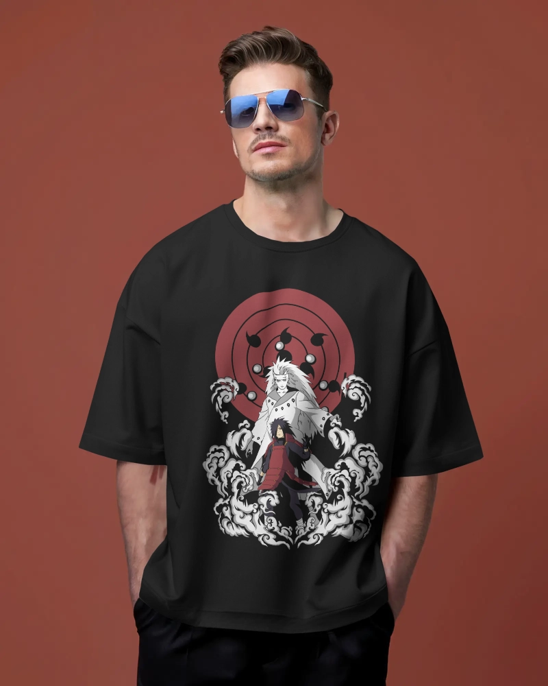 Man standing with his hand in his pocket, wearing an oversized black cotton t-shirt featuring a print of Ghost Uchiha Madara from the anime.